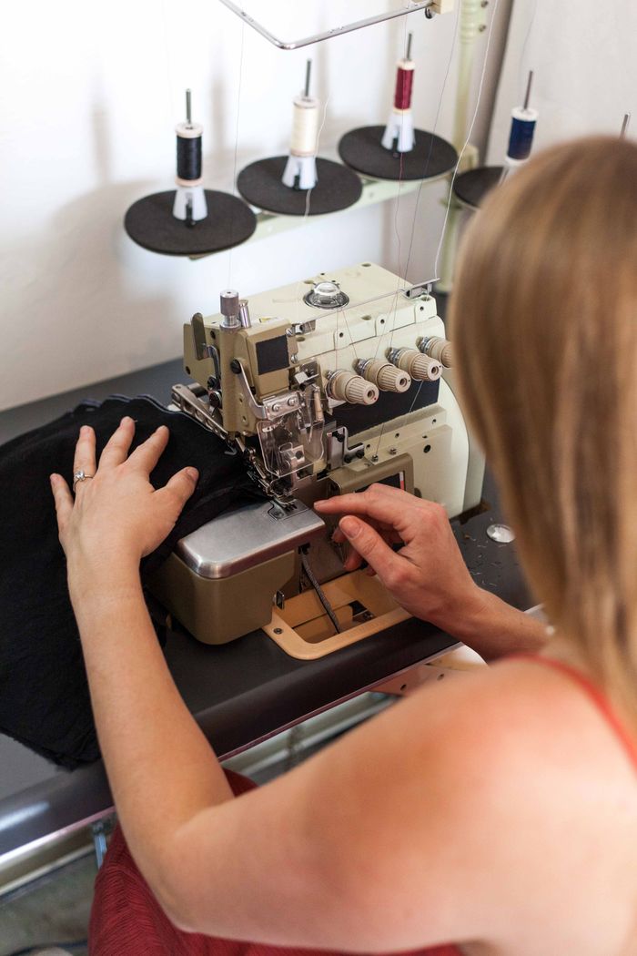 creative-03 Woman sewing fabric on an industrial sewing machine, focusing on fashion design.